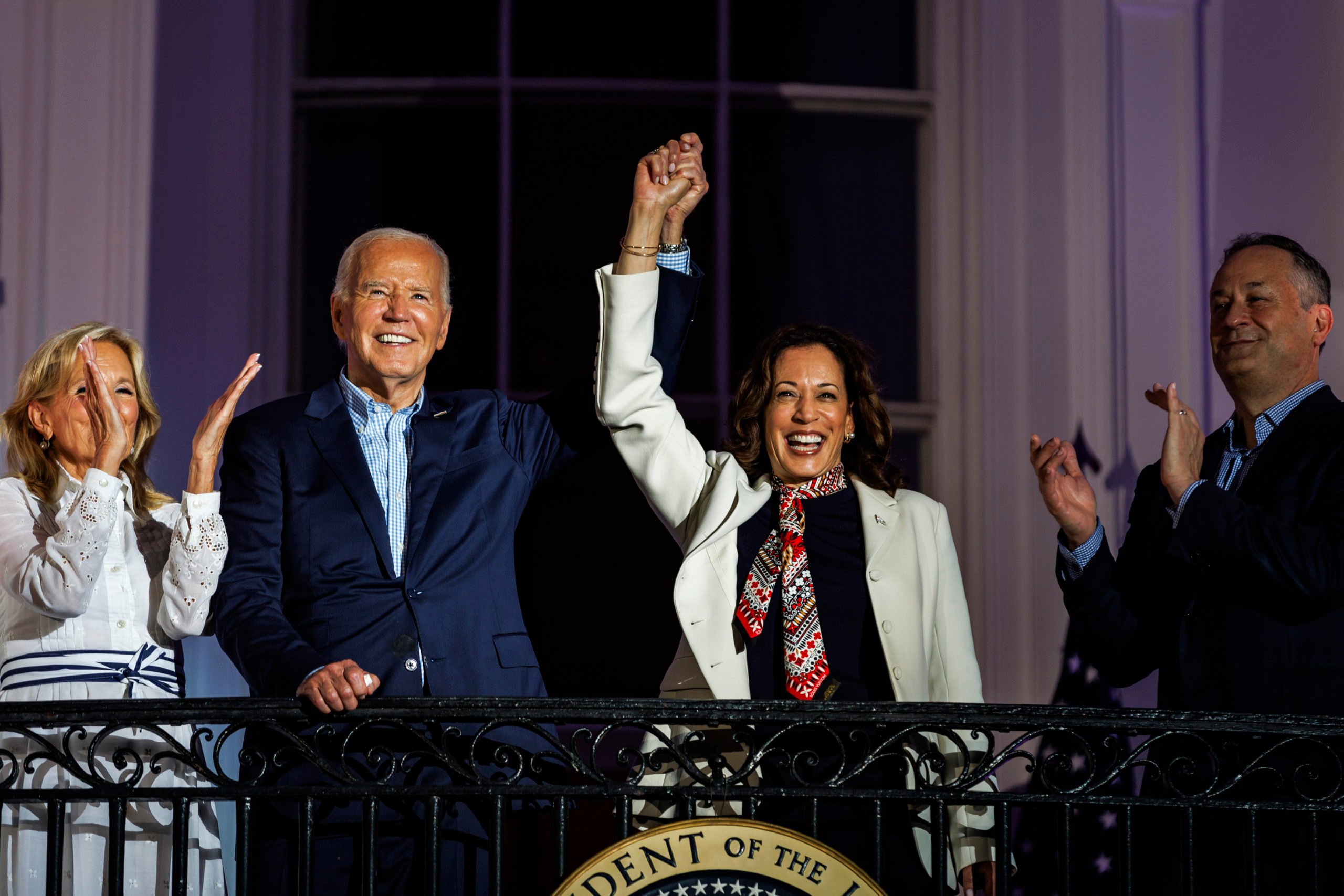 President Joe Biden and Vice President Kamala Harris join hands in the air as they view the fireworks on the National Mall with First Lady Jill Biden and Second Gentleman Doug Emhoff from the White House balcony during a 4th of July event on the South Lawn of the White House on July 4, 2024 in Washington, DC. The President is hosting the Independence Day event for members of the military and their families. (Photo by Samuel Corum/Getty Images)